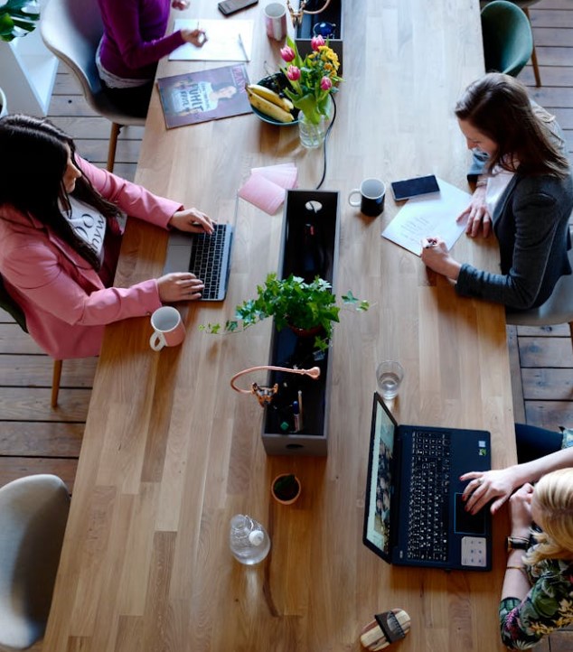 Femmes assises à un bureau en train de travailler en coworking