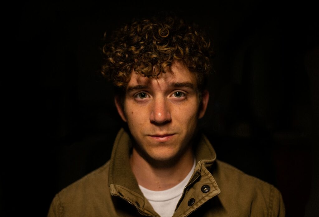 man wearing brown collared top